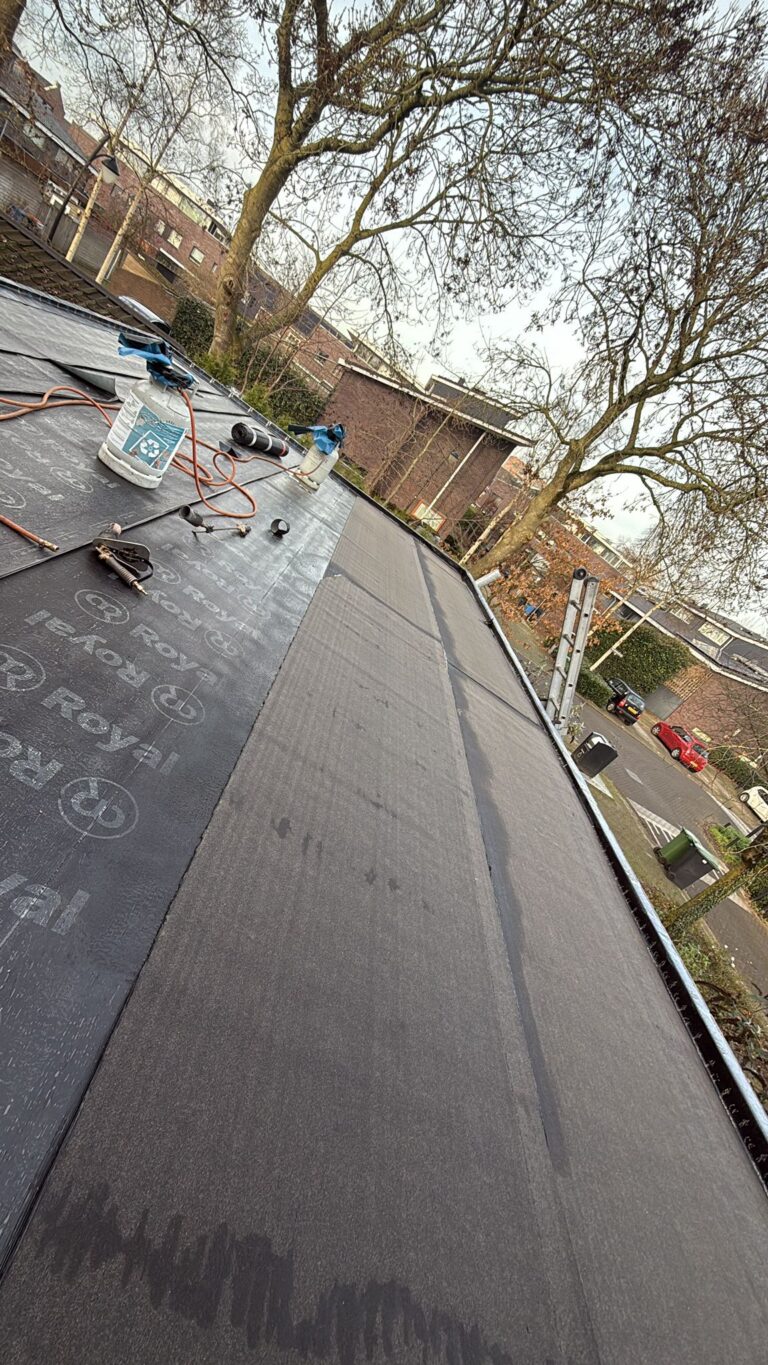 Wortelwerende bitumen dakbedekking aangebracht op een plat dak tijdens een dakrenovatie in Amersfoort.