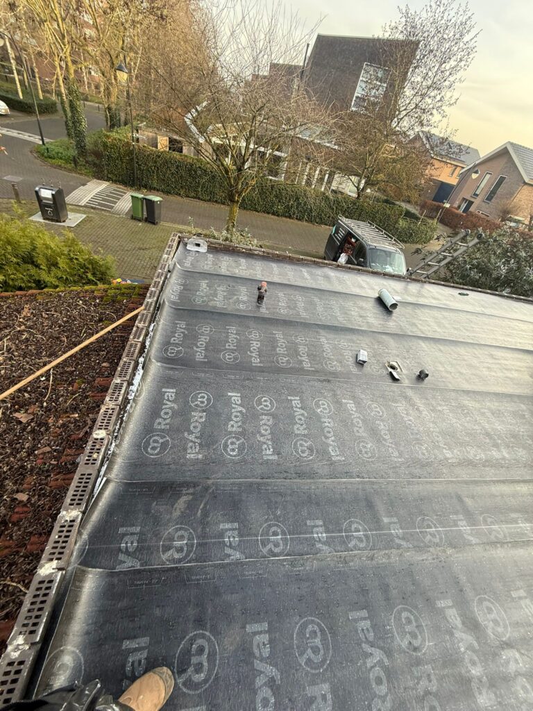 Wortelwerende bitumen dakbedekking aangebracht op een plat dak tijdens een dakrenovatie in Amersfoort.