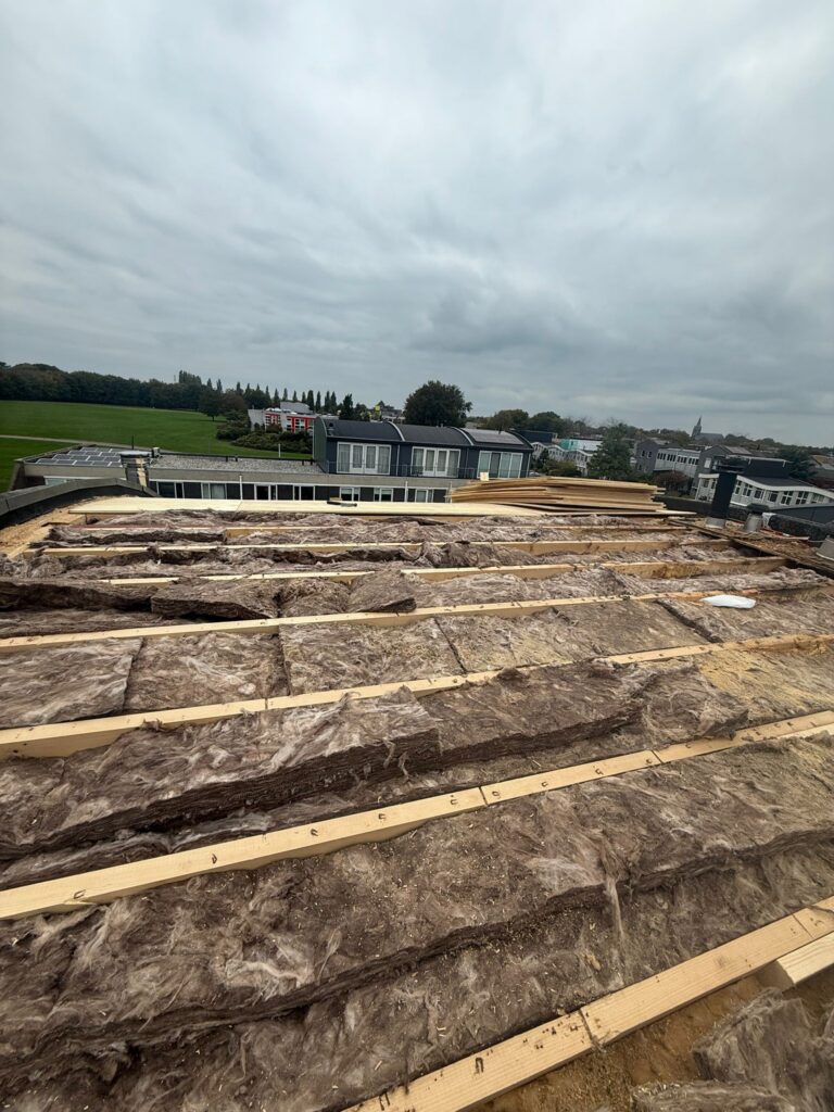 Dakrenovatie in Amersfoort met nieuwe dakbalken, isolatie, underlayment en afgewerkt met duurzame bitumen dakbedekking.
