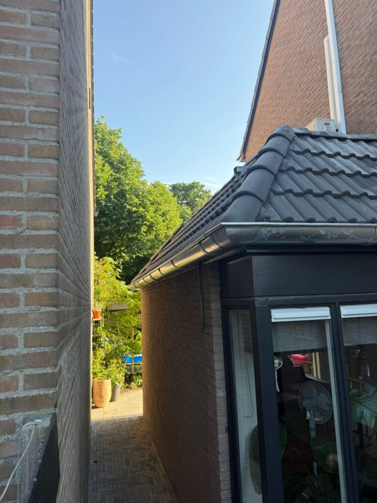 Dakrenovatie in Spakenburg met vernieuwd pannendak, zinkwerk op het platte dak, dakkapel en vernieuwde dakgoten.