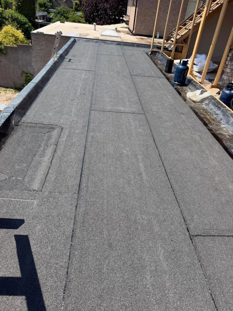Nieuw bitumen plat dak naast een houten dakopbouw in aanbouw in Ede