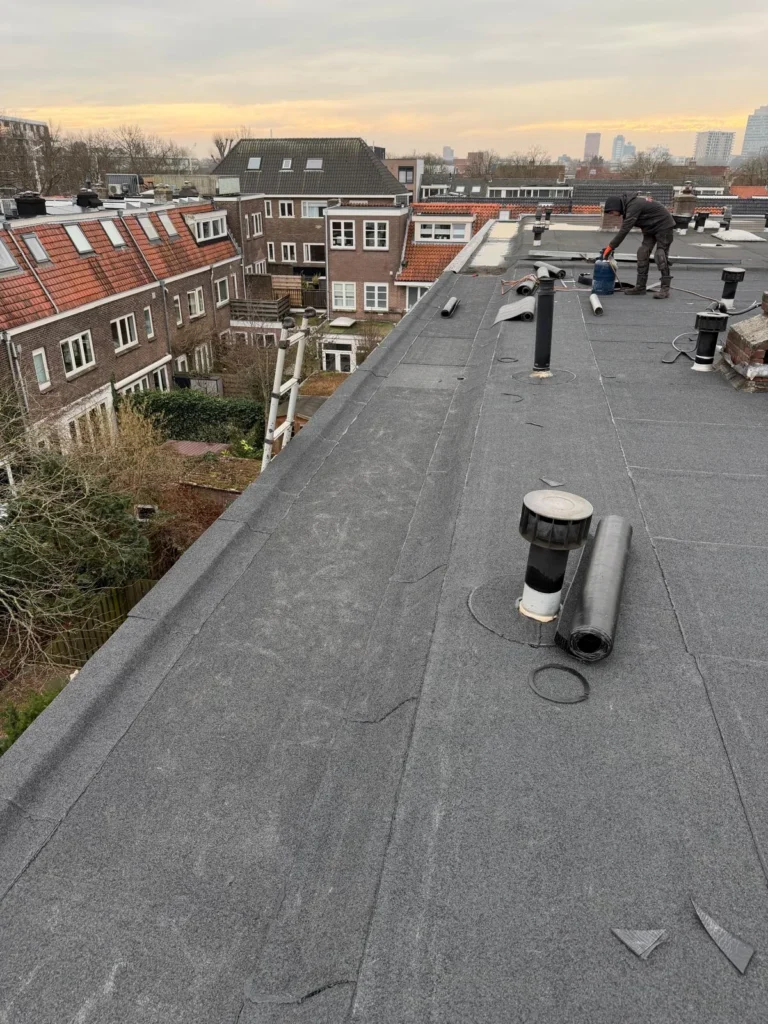 Dakdekker brandt bitumen dakbedekking op een plat dak