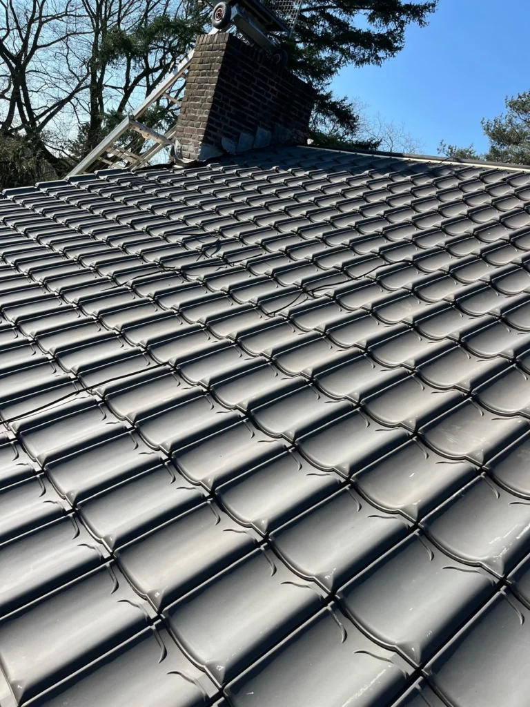 Nieuw pannendak met donkere geglazuurde dakpannen en schoorsteen in Ede
