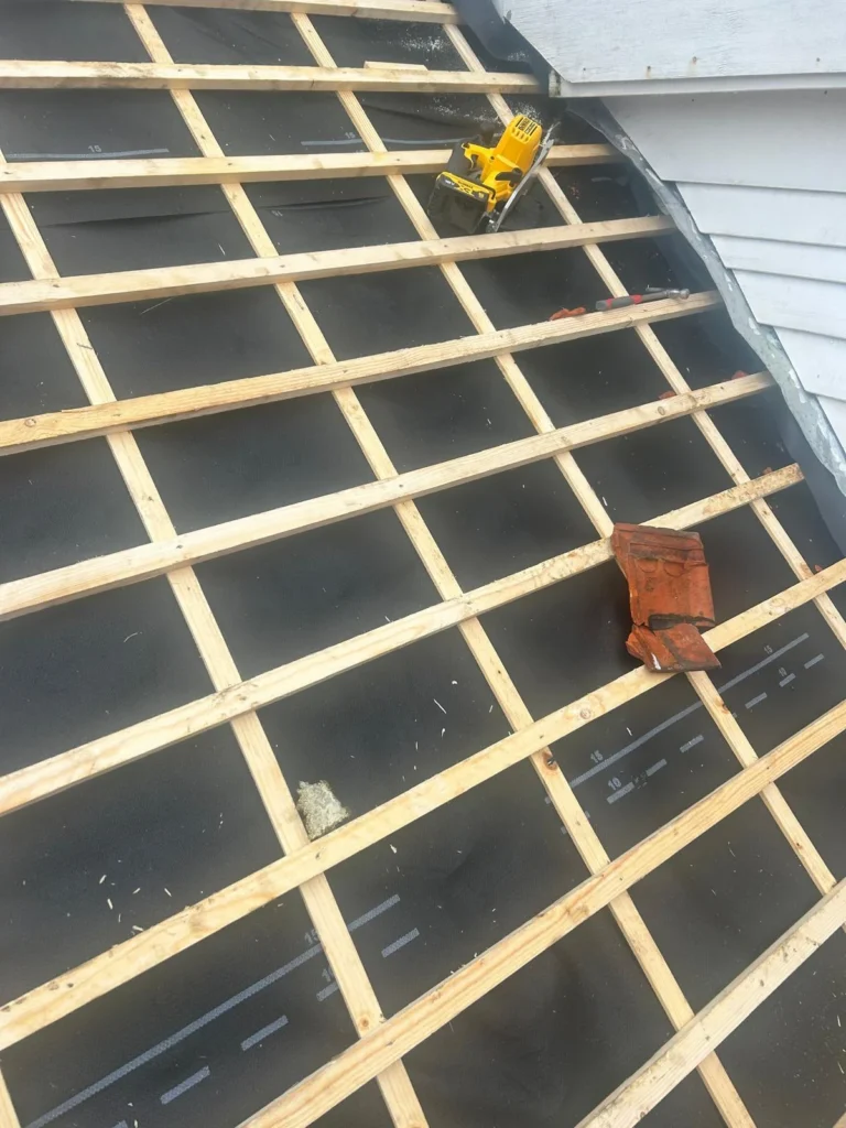 Nieuwe panlatten op folie met een oude dakpan en cirkelzaag in Ede