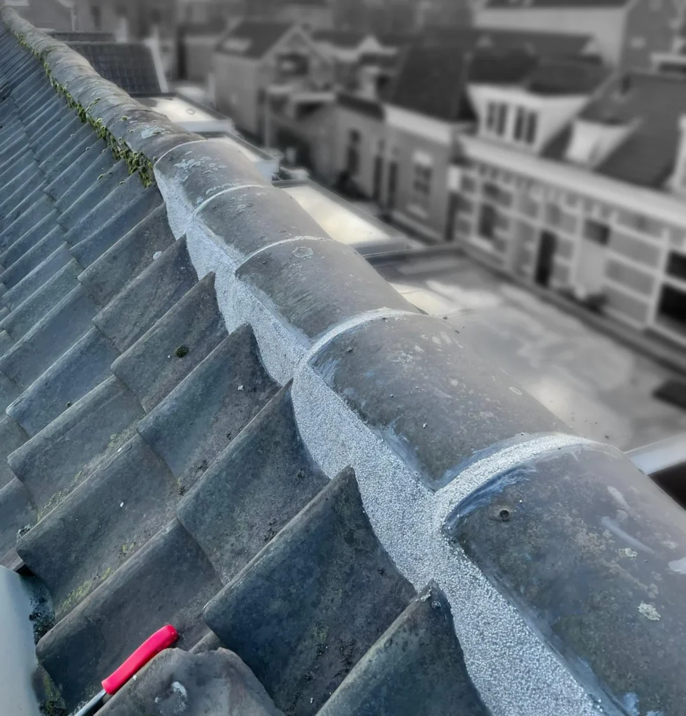 Oude nokvorsten opnieuw aangesmeerd met nieuwe mortel in Ede